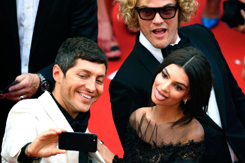Cô đào nóng bỏng Emily Ratajkowski làm trò khi chụp ảnh nhóm cùng các đồng nghiệp nam trên thảm đỏ Cannes vào ngày 18/5.