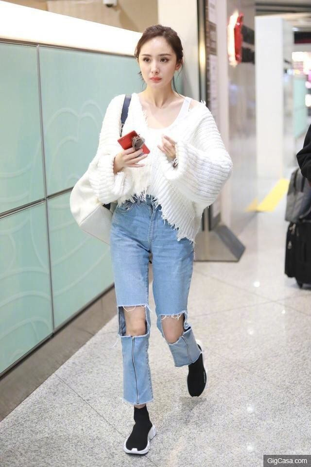 Quần jeans là món đồ yêu thích của Dương Mịch khi ra sân bay. Nữ diễn viên lăng xê trào lưu diện jeans cắt ô vuông ở đầu gối, diện cùng áo len tua rua tạo nên vẻ bụi phủi.