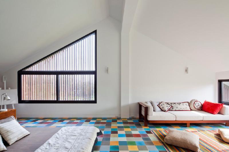 Toàn bộ tầng áp mái được thiết kế thành một phòng ngủ lớn đầy màu sắc, tách biệt với lối kiến trúc ở các tầng dưới.