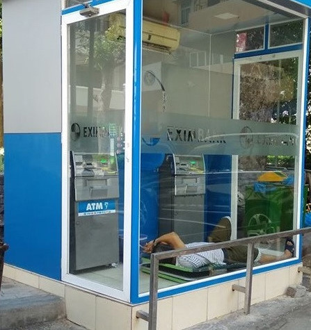 Người đàn ông ngủ trong cây ATM có điều hòa mát lạnh. Đây là ý tưởng của không ít người dân trong những ngày nắng lên đến hơn 40 độ C. Ảnh: 