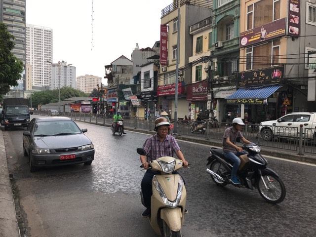 Người dân di chuyển trên đường Vũ Trọng Phụng, quận Thanh Xuân vội vàng mặc áo mưa hoặc tìm chỗ tránh mưa