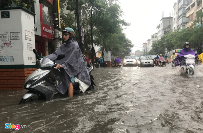 Cơn mưa bắt đầu lúc 7h30 ở nội thành với cường độ lớn ngay lập tức gây xáo trộn giao thông do đúng giờ người dân đi làm. Ảnh: Tiến Tuấn.