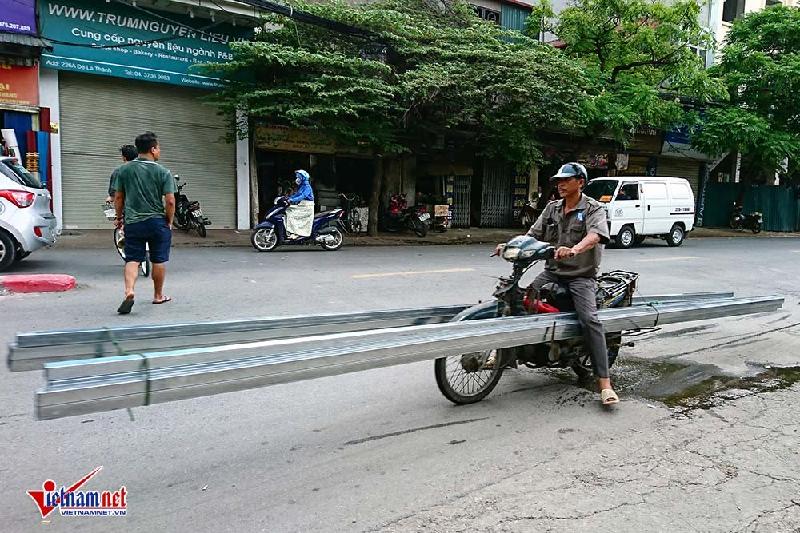 Những chiếc xe máy trơ khung, cũ nát được tận dụng để chở hàng từ những thanh sắt đến những tấm tôn vẫn tồn tại trên phố Hà Nội, uy hiếp người đi đường