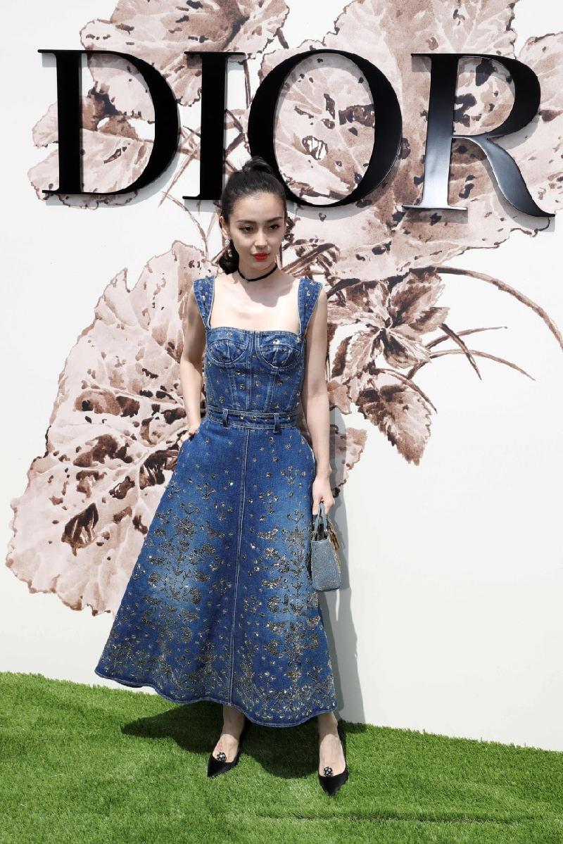 Mới đây, nữ diễn viên Angelababy làm khách mời tại show thời trang Dior Couture ở Paris, Pháp. Cô là một trong những ngôi sao châu Á quen mặt trong các sự kiện của nhà mốt này. Angelababy mặc bộ đầm bằng vải denim với họa tiết thêu chìm, phần thân cúp ngực gợi cảm. Người đẹp buộc tóc cao, tô son nổi bật. 