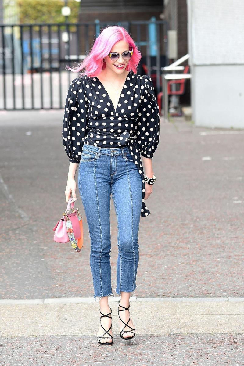 Pixie Lott trẻ trung với sơ mi cuốn eo, quần jeans cạp cao và sandal cao gót khi dạo phố London. Mái tóc màu hồng giúp cô trông rạng ngời hơn.