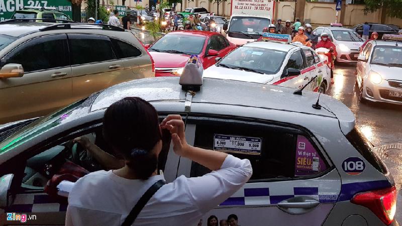 Một phụ nữ vẫy taxi nhưng không được tài xế đáp ứng vì lý do ùn tắc mưa ngập khắp nơi. Ảnh: Hoàng Hà.