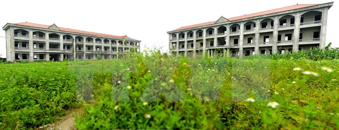 Trường trung học phổ thông Vũ Duy Thanh hiện vẫn phải nằm ​'đắp chiếu' giữa muôn trùng cỏ cây. (Ảnh: Minh Đức/TTXVN)