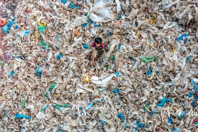 Sống chung với rác. (Nguồn: NatGeo) Một đứa trẻ đang chơi trên bãi rác ở Dhaka, Bangladesh.
