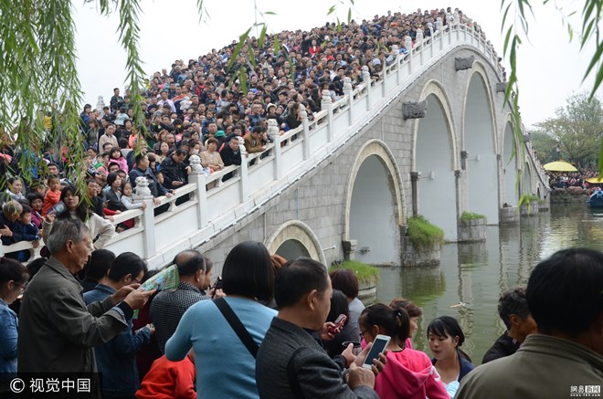 Hình ảnh này được ghi lại tại Vườn Thanh Minh Thượng Hà ở Khai Phong, Hà Nam (Trung Quốc) khi du khách đang xem biểu diễn trên một cây cầu. (Nguồn: 163)
