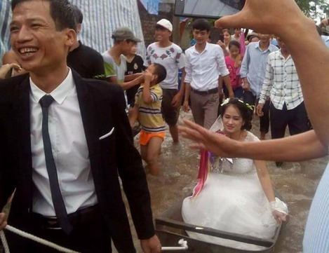 Chú rể cười tươi lội nước kéo thuyền chở cô dâu làm đám cưới