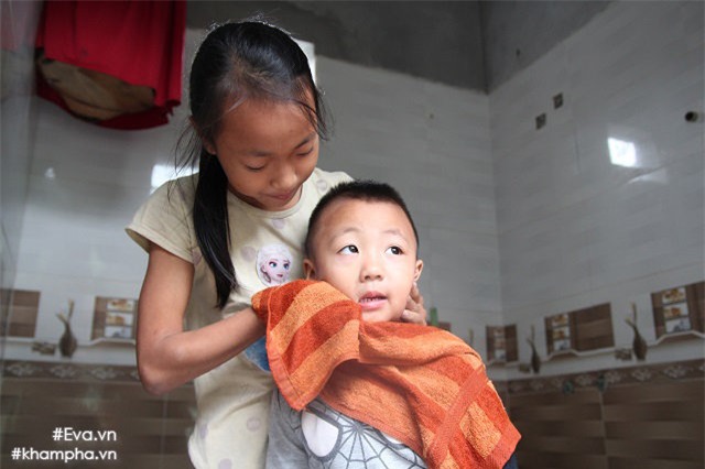 Khi bố và bà đi làm, chị gái là Đỗ Thị Dung (SN 2006) đi học, Duyên lại tiếp tục chăm sóc các em. Trong ảnh: Duyên đang rửa mặt cho em trai thứ 5 để chuẩn bị cho em đi ngủ.