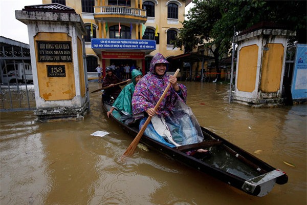 Người dân phải chèo thuyền để di chuyển (Ảnh Reuters)