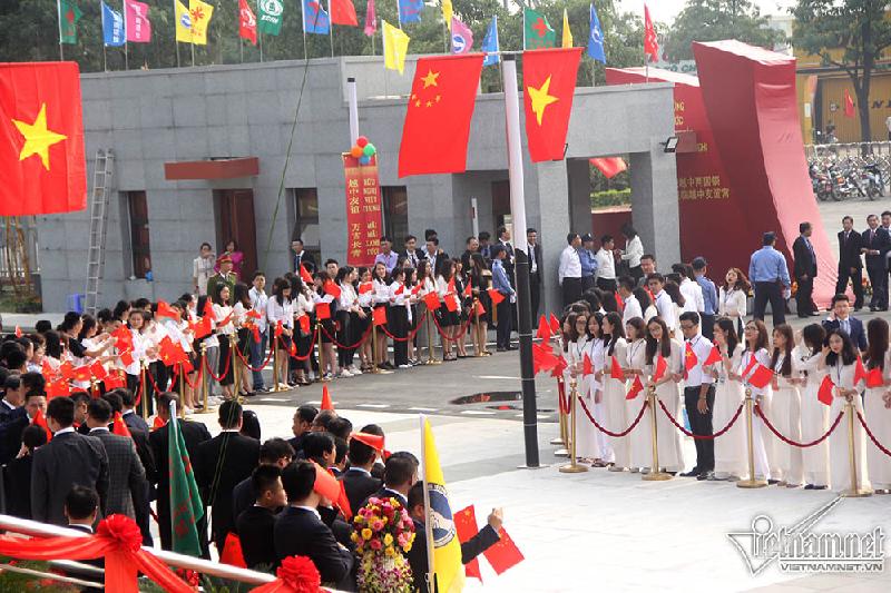 Sinh viên và du học sinh 2 nước cầm cờ đứng 2 bên chào đón các đại biểu tham dự