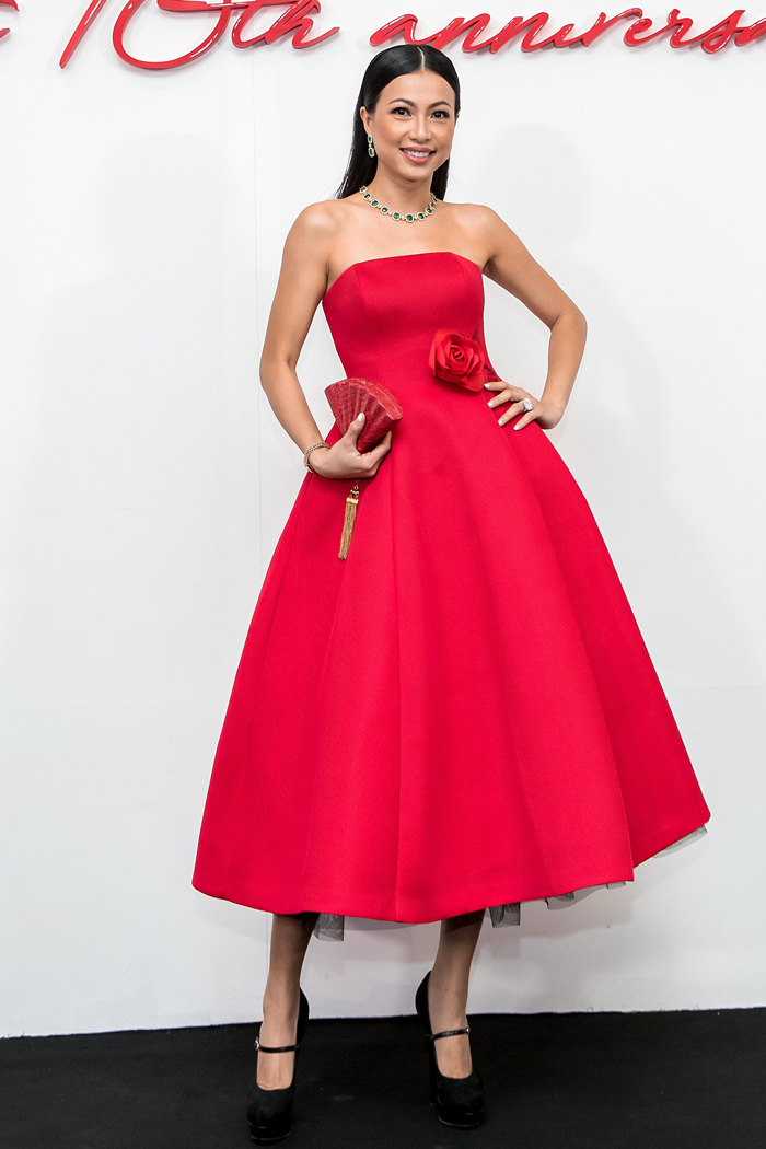 Hoa hậu Ngô Mỹ Uyên diện đầm xoè cúp ngực với điểm nhấn là hoa hồng ở thắt eo. Người đẹp phối trang phục cùng clutch cầm tay độc đáo, trang sức màu xanh nổi bật.