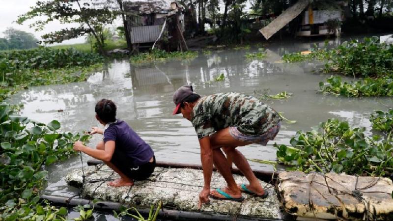 Người dân Mindanao làm một chiếc bè tạm bợ để di chuyển qua những khu vực bị ngập. (Ảnh: EPA)