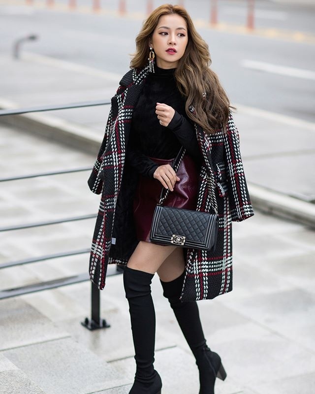  Chi Pu khoe street style chuẩn Idol xứ Hàn với công thức áo dạ dáng dài mix ngoài chân váy da, áo len và boots chun cao đến đùi.