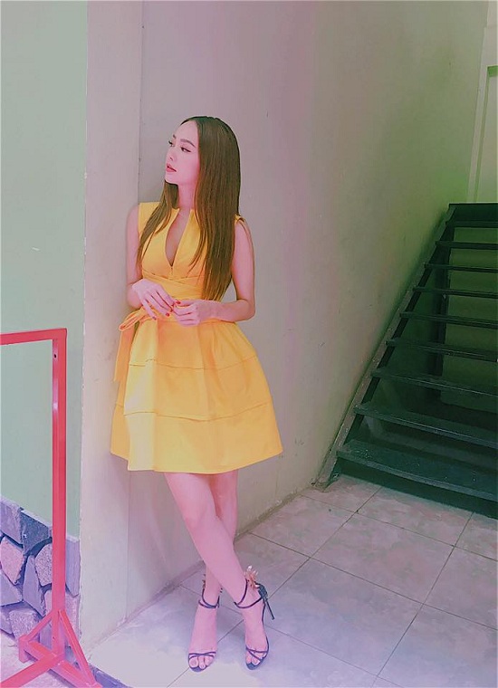 Ca sĩ Minh Hằng diện trang phục màu vàng nổi bật, đứng dựa người vào tường như trông ngóng ai đó. Cô đăng tải hình ảnh kèm theo chú thích: “Bả đứng rình ai nữa không biết”.