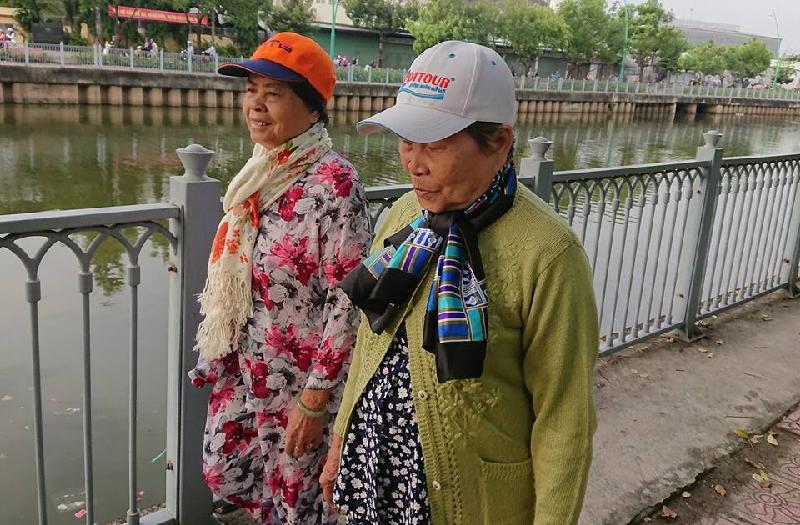 Hai người phụ nữ choàng khăn ấm đi tập thể dục ở kênh Nhiêu Lộc sáng nay.   