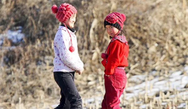 Hai bé gái chơi trên bờ sông Yalu, huyện Sakchu. (Ảnh: Reuters)