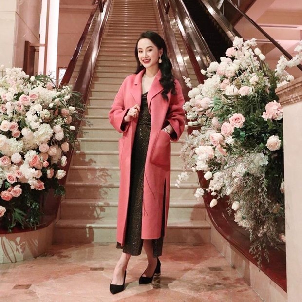 Angela Phương Trinh có phần chững chạc, sắc sảo khi mặc đầm ánh nhũ với áo khoác dáng dài, trang điểm đậm.
