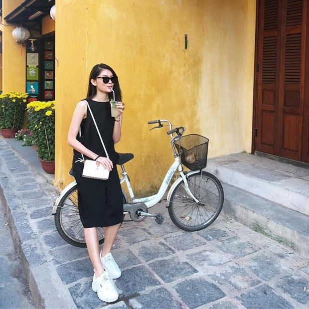 Á hậu Thùy Dung diện đầm đen dáng rộng với sneakers trắng mang cảm hứng tối giản khi đi du lịch phố cổ Hội An.