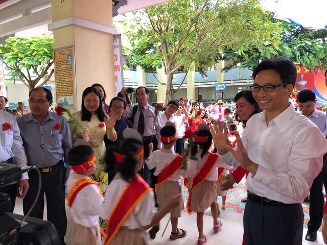 Phó Thủ tướng Vũ Đức Đam vẫy tay chào đón học sinh lớp 1 trường Tiểu học Lê Văn Tám (quận 7, TPHCM).